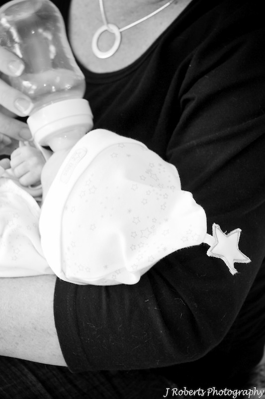 Baby feeding in mothers arms with little star hat on - baby portrait photography sydney